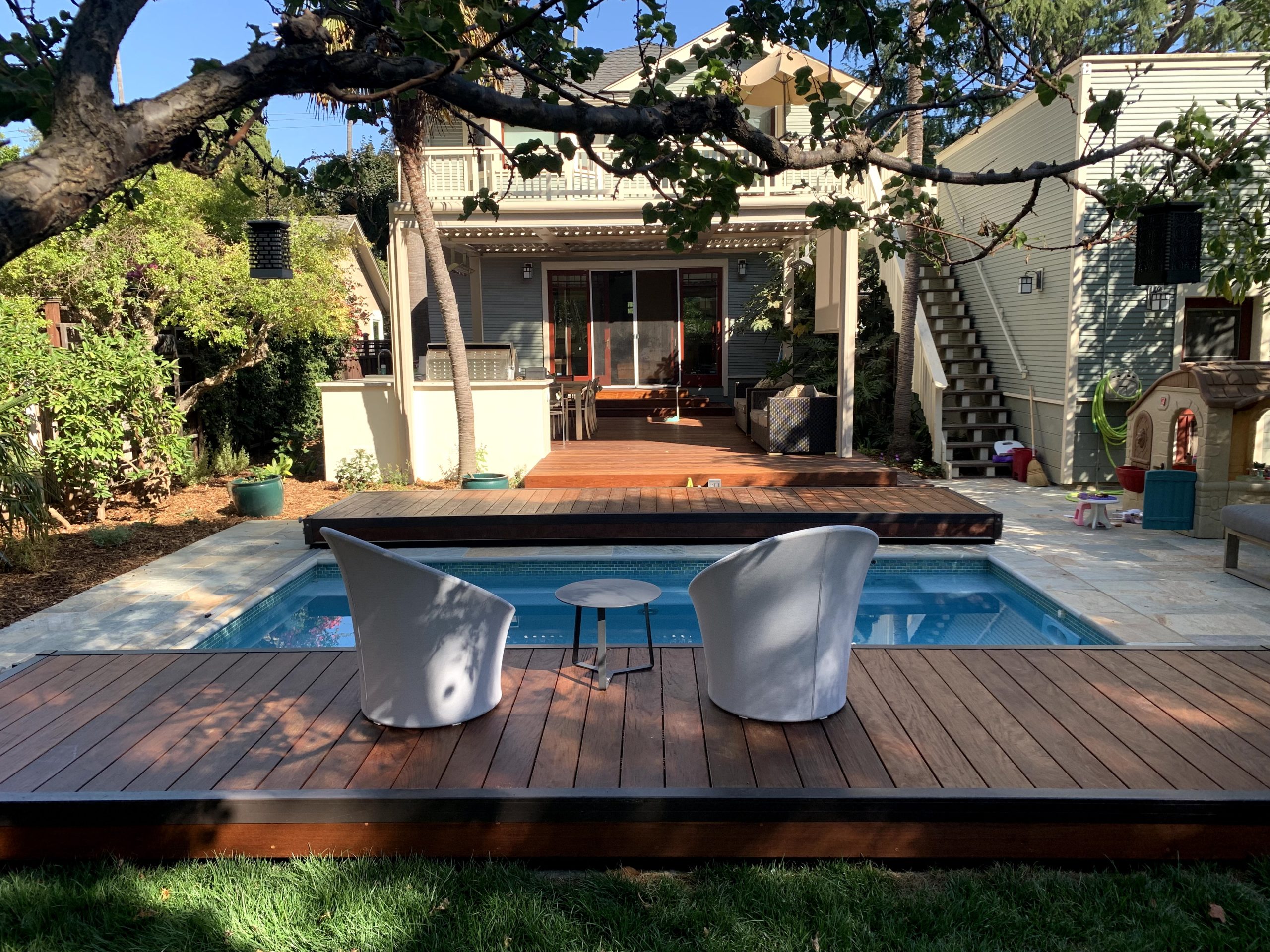 Sliding pool deck cover partially open showing pool and outdoor seating area